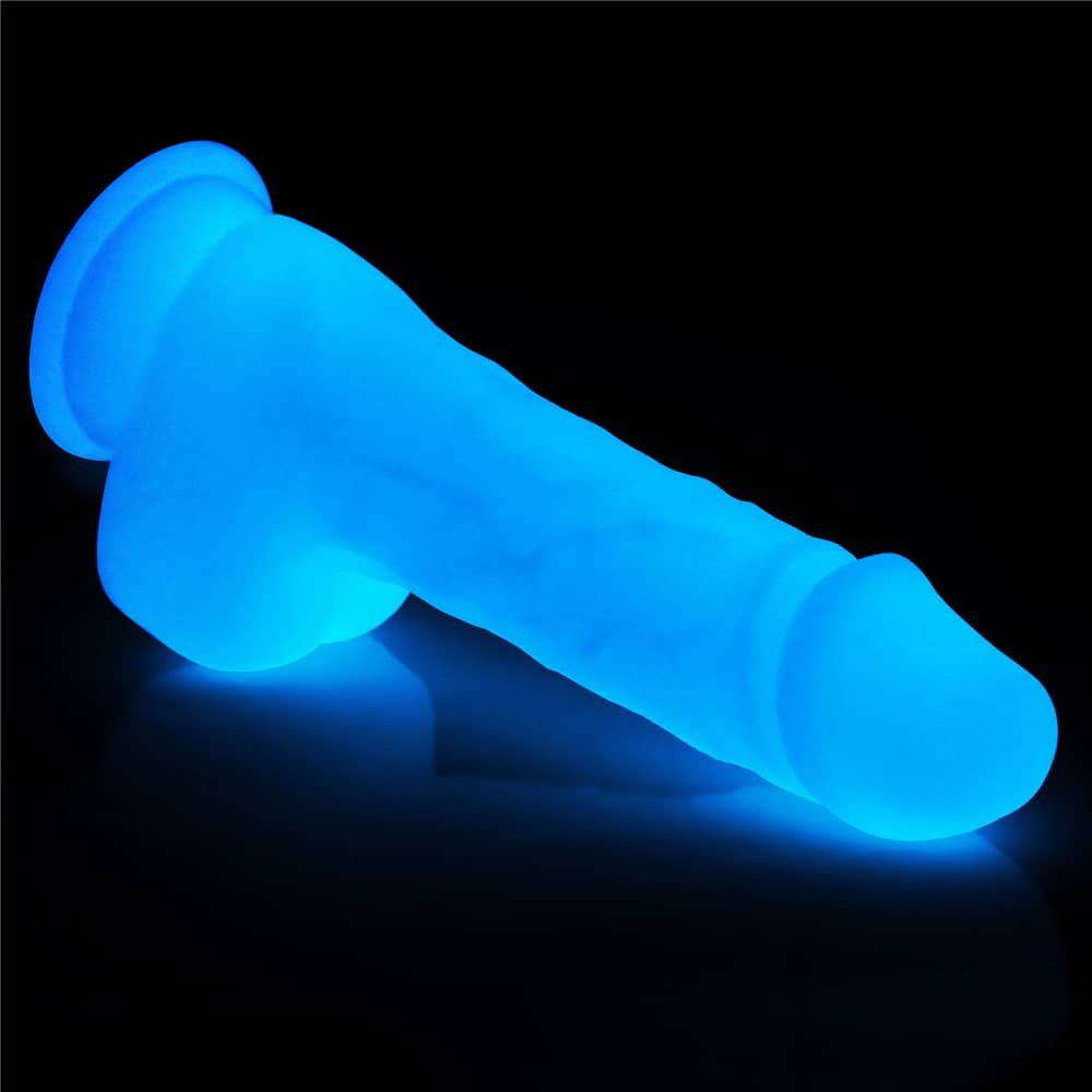 The 7.5 inches lumino play silicone dildo lays flat emitting blue fluorescence 
