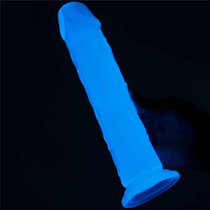 The 8 inches lumino play dildo emitting blue fluorescence is held by a man 
