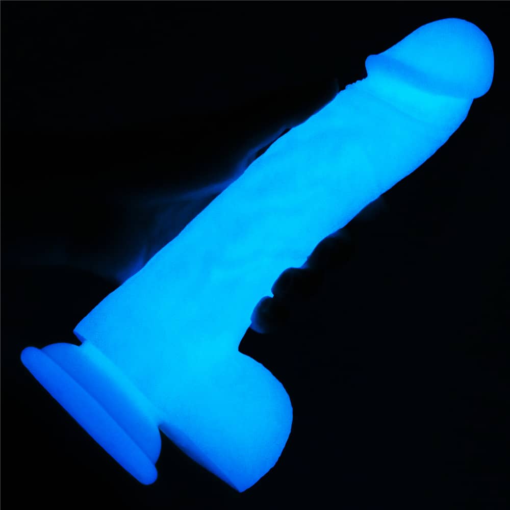 A man holds the 8 inhces lumino play silicone dildo in the dark