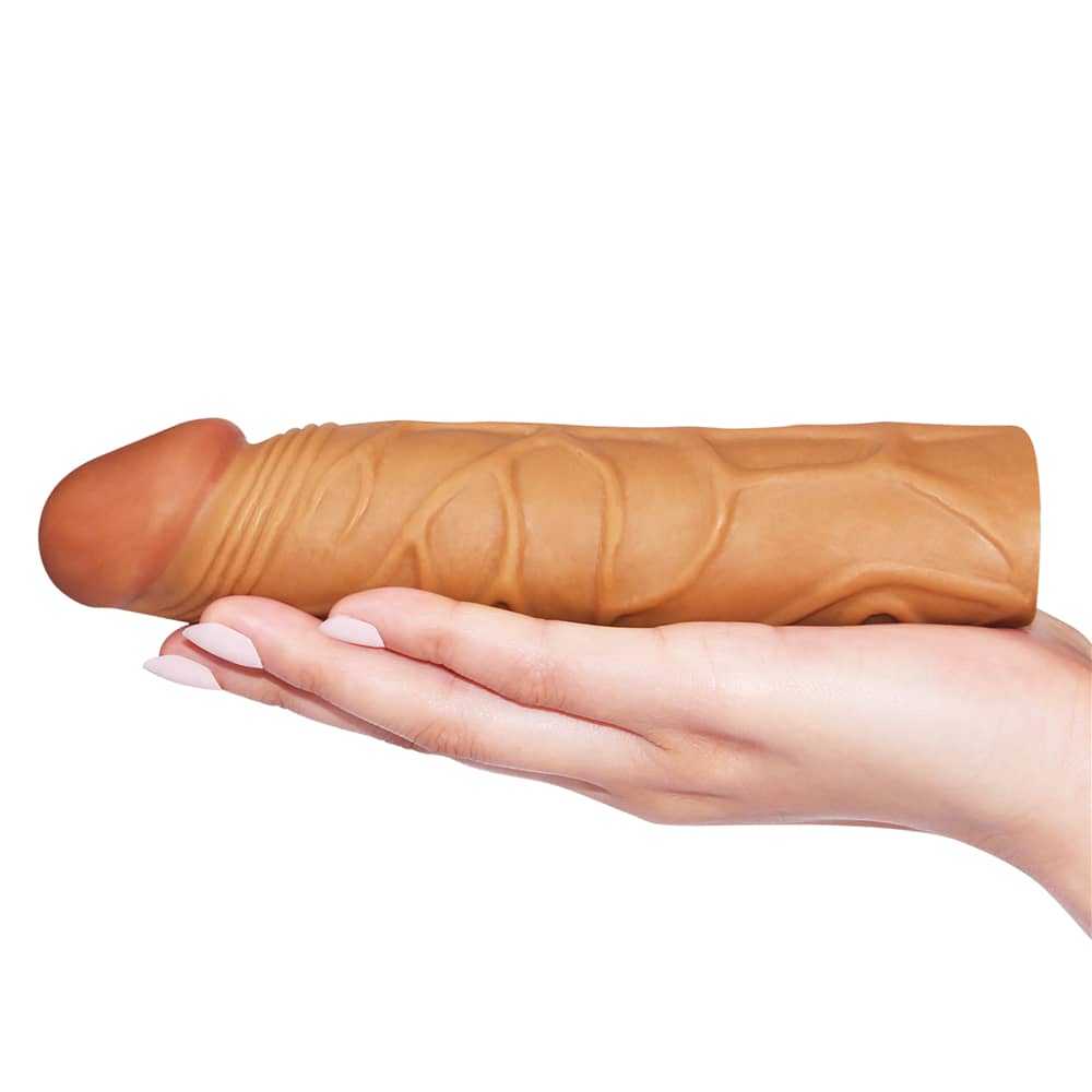The add 1 inches pleasure x tender brown penis sleeve lays flat on the palm