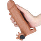A man holds the brown add 2 inches vibrating penis sleeve