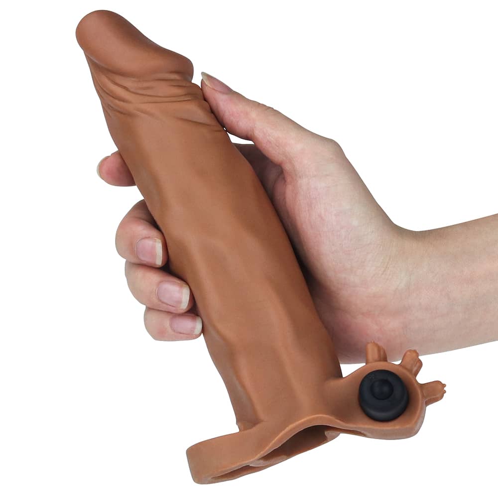 A man holds the brown add 2 inches vibrating penis sleeve