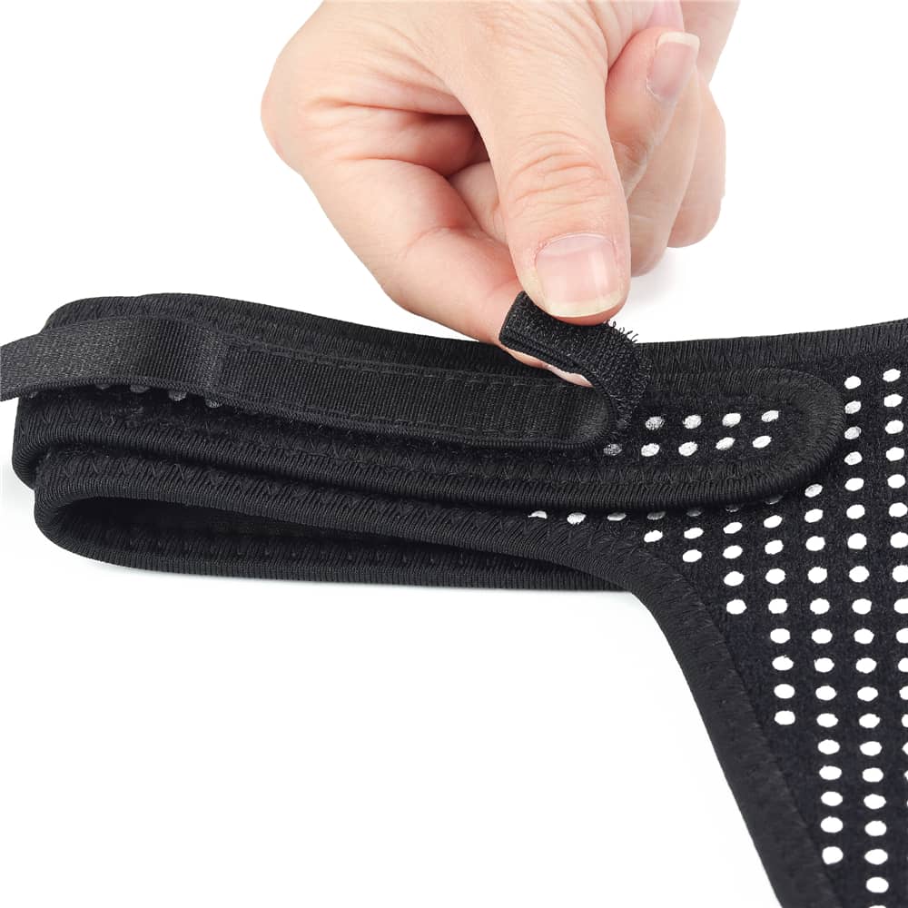 A persone holds the elastic webbing of the polka dots easy strap on harness