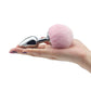 The pink pompon metal plug small silver is put on the palm
