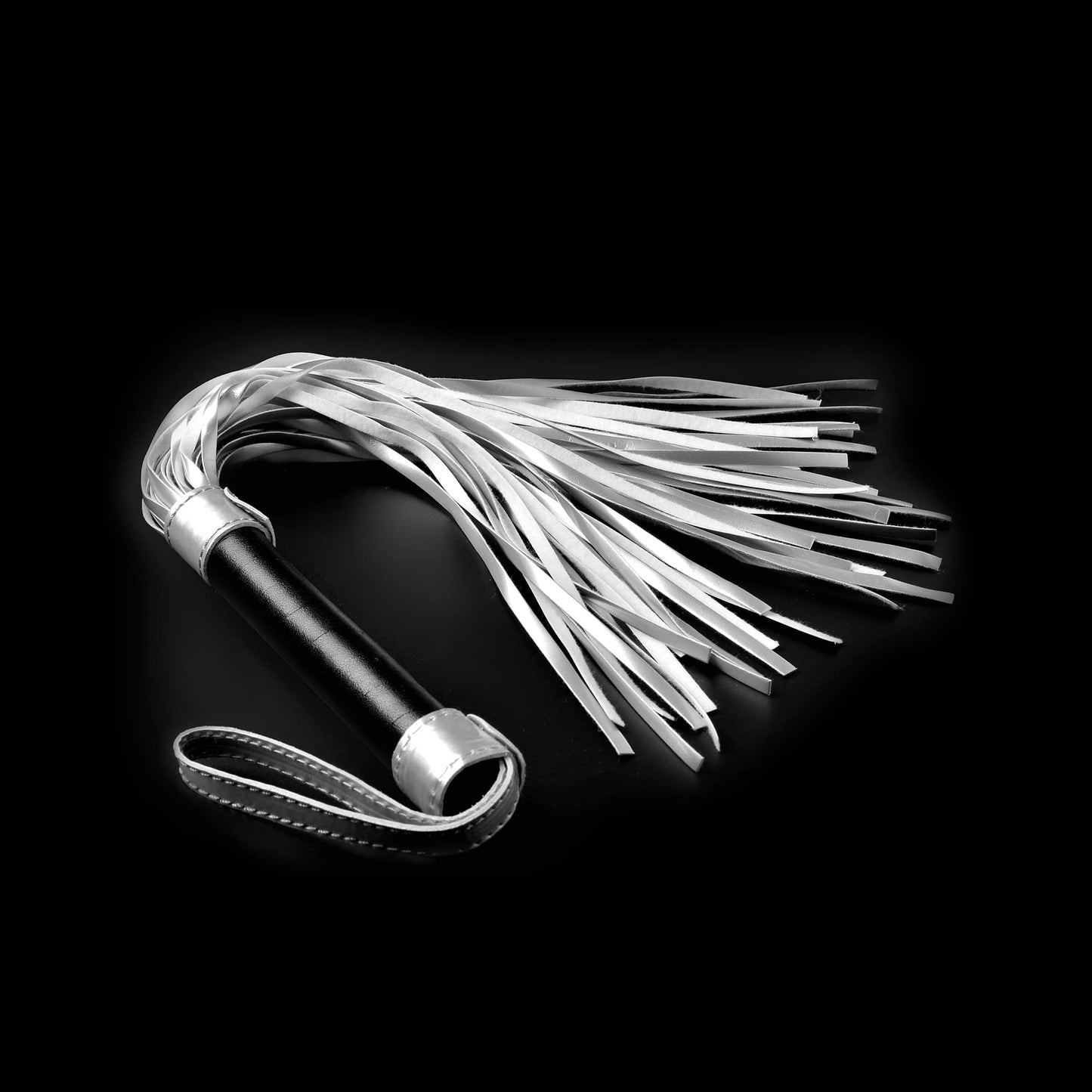 The bdsm sex whip flogger for kinky play lays flat
