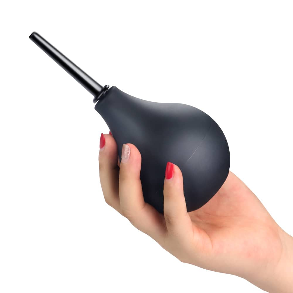 A woman holds the squeezable deluxe anal douche bulb